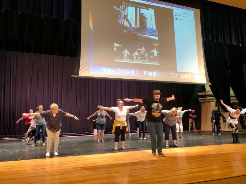 Group performing movement exercise on stage